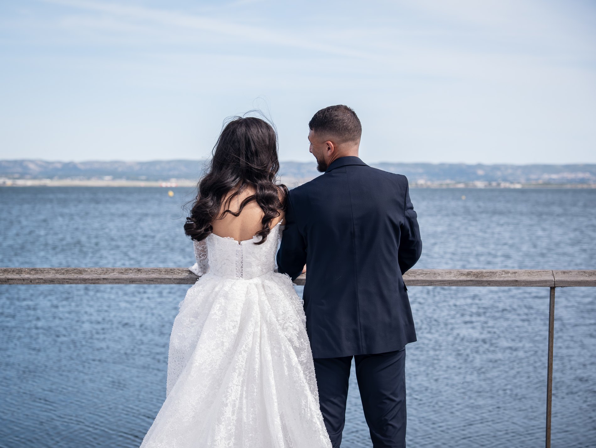 Les mariés contemplent la mer, de dos